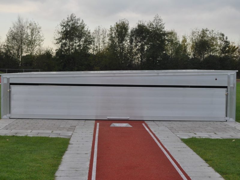 Stationary safety cover for pole vault landing areas